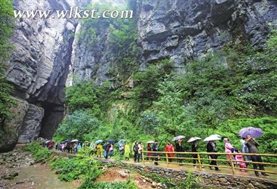 5月31日，天生三硚飘着细雨，丝毫没有降低游客对武隆山水的热爱之情。 （代君君/摄）